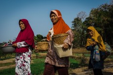 Villagers, carrying food in their baskets, walk to the Wonosadi customary forest. JP/Anggertimur Lanang Tinarbuko