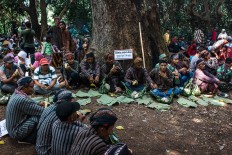 Villagers – clad in Javanese traditional costumes – sit on the ground under the shade of the trees of the Wonosadi forest. JP/Anggertimur Lanang Tinarbuko