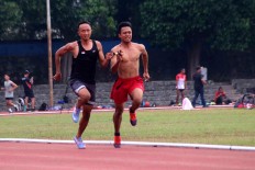 A visually impaired runner jogs alongside his chaperone during a training session. JP/Maksum Nur Fauzan]