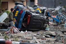 A man looks for belongings from his house after it was damaged in Palu in Central Sulawesi on September 29, 2018, following a strong earthquake and tsunami that struck the area. Nearly 400 people were killed when a powerful quake sent a tsunami barrelling into the Indonesian island of Sulawesi, officials said on September 29, as hospitals struggled to cope with hundreds of injured and rescuers scrambled to reach the stricken region. AFP/ Bay Ismoyo