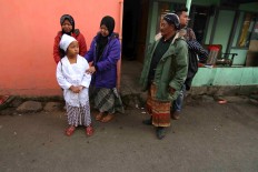 Salwa Qoirunisa is accompanied by her family prior to the haircutting ritual. JP/Maksum Nur Fauzan