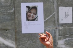 A survivor holds up a picture of a missing girl in Palu on Friday, October 5, 2018. JP/Dhoni Setiawan