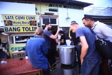 Australian journalists take a break to buy food at a food stall as they carry out their task of covering the deadly earthquake and tsunami on Wednesday, October 3, 2018. The National Disaster and Mitigation Agency (BNPB) announced on Thursday, October. 4, 2018. that the number of victims reached 1,581 people while 2,549 were injured and 113 were still missing. JP/Dhoni Setiawan