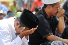 Two men weep after performing their Friday prayers in the front yard of the Darussalam Grand Mosque in Palu on Friday, October 5, 2018. The mosque was badly damaged by the strong earthquake and therefore religious activities are being conducted in the front yard, which also serves as a shelter for evacuees. JP/Dhoni Setiawan