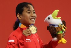 Moment of pride: Indonesian swimmer Syuci Indriani gives a salute after winning the gold medal in the 100-meter freestyle competition at the Gelora Bung Karno Aquatic Center in Senayan, Central Jakarta. INAPGOC/TJPimages/Hendra