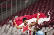 Victory lap: Indonesia&rsquo;s Sapto Yogo Purnomo raises the red and white flag of Indonesia after winning the gold medal in the 200-meter para-athletics event at the Gelora Bung Karno sports complex in Senayan, Central Jakarta. INAPGOC/TJPimages/Muhammad Bagas Syahputra