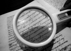 A magnifying glass is used to read the Javanese characters in a manuscript. JP/Ganug Nugroho Adi