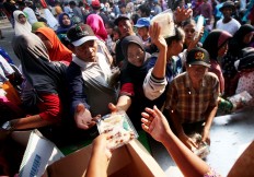 Villagers line up for packages containing nasi uduk (steamed rice in coconut milk), shredded chicken and fried peanuts. JP/Boy T. Harjanto