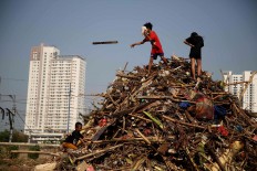 Children play on a pile of garbage consisting mainly of tree trunks, logs and bamboo in Tanah Abang, Central Jakarta, on Thursday, October 25, 2018. The garbage was collected from the West Flood Canal. JP/PJ Leo