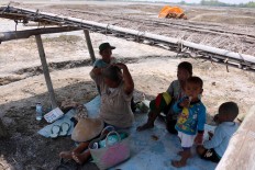 Siem and her family rest in the shade while guarding their salt production. JP/Maksum Nur Fauzan