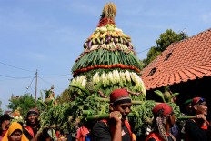 A cone-shaped offering is paraded. JP/Magnus Hendratmo