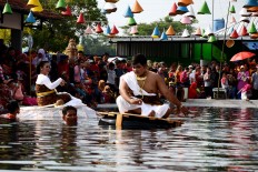 A man and a woman ride on rafts during the Sri Mulyono and Sri Mulyani performance, depicting the harmony of the water spring in Pluneng village. JP/Magnus Hendratmo