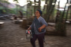 Yuli carries her grilling tools to the market. She usually grills traditional cakes. JP/P.J.Leo