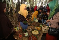 Sanah serves a customer who bought a portion of nasi kuning (rice steamed in turmeric and served with side dishes). JP/P.J.Leo