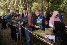 Joana Stevens, an Australian who lives in Jakarta, exchanges her rupiah for bamboo “money” at the market cashier. JP/P.J.Leo