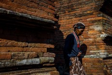 An abdi dalem (courtier) enters the Supit Urang Gate in the morning at the tombs of the Mataram kings. JP/Anggertimur Lanang Tinarbuko