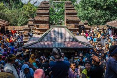  Courtiers from the Surakarta Hadiningrat palace help distribute sacred water in a bucket. JP/Anggertimur Lanang Tinarbuko