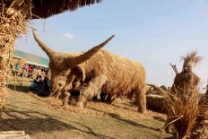 Ready to attack: The Straw Festival includes an enormous bovine  sculpture, which refers to fossils discovered in the village.  JP/Maksum Nur Fauzan