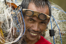 Satisfaction: A villager smiles after catching some fish with his nets. JP/Tarko Sudiarno
