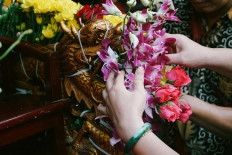 The cultural parade participants decorate a joli (stretcher) with orchids. JP/Donny Fernando