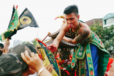 A tatung (a man possessed by a spirit) smears blood on someone’s forehead during the parade. JP/Donny Fernando