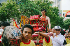 A tatung (a man being possessed by a spirit) is doing an extreme attraction during the parade on Jl. Gajah Mada. JP/Donny Fernando