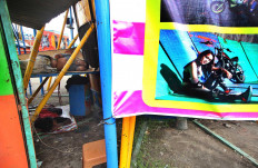 Sweet dreams: Men sleep beside a poster af a local stunt woman. JP/Boy T Harjanto