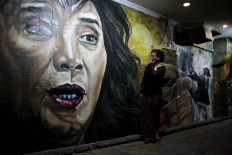 Super minister: Maritime Affairs and Fisheries Minister Susi Pudjiastuti looks at a mural that depicts her as DC Comics character Wonder Woman. JP/Maksum Nur Fauzan