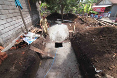 A village administration official monitors the making of a digester well. JP/Maksum Nur Fauzan