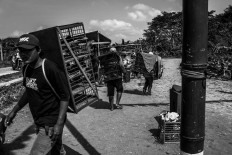 Owners carry their birds in a layered cage on their backs. Each cage can accommodate four pairs. JP/Anggertimur Lanang Tinarbuko