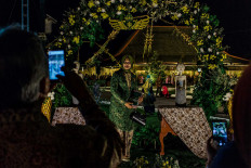 A female guest takes a picture in a photo booth. JP/Anggertimur Lanang Tinarbuko