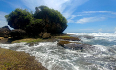 A giant rock is an attraction at Legok Jawa Beach. Due to strong waves and currents, tourists are not allowed to swim there. JP/Arya Dipa