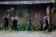Children walk in the rain before joining the festival. JP/Maksum Nur Fauzan