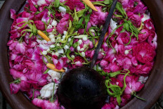  A jug of water filled with rose petals and jasmine acts as a prop for a performance. JP/Maksum Nur Fauzan