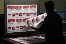 A staff is checking the color quality of each random sample coming from the printing machine. JP/Dhoni Setiawan