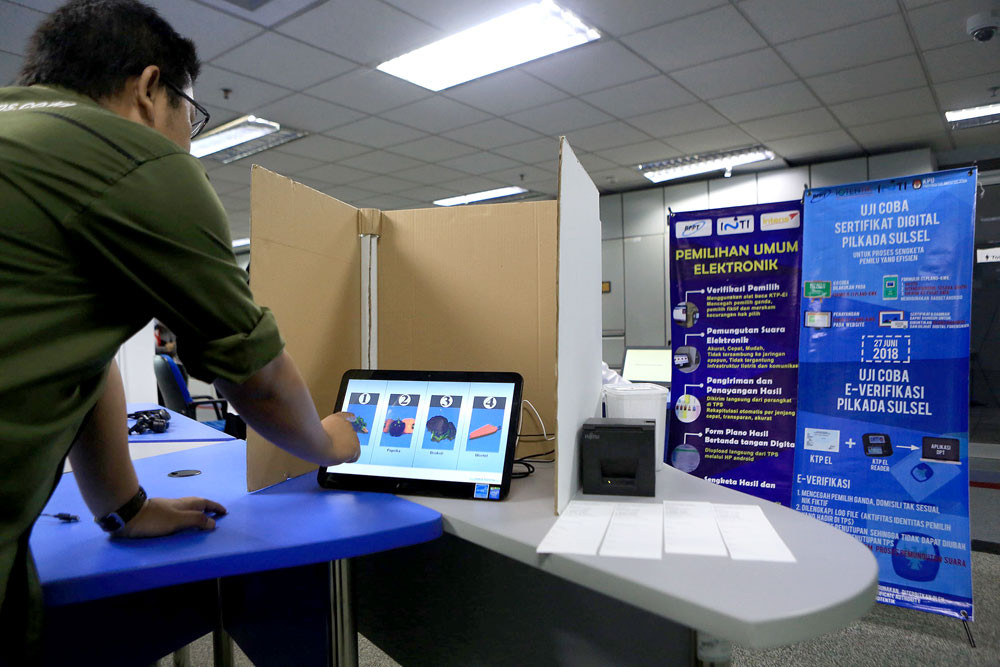Going digital: An Agency for the Assessment and Application of Technology official demonstrates the e-voting system in Jakarta. The government may implement e-voting to replace the manual voting system. Hundreds of polling station workers reportedly died of fatigue after days of organization and ballot reporting.