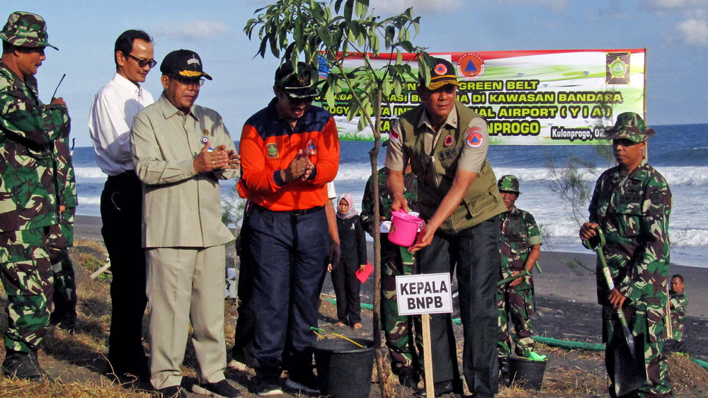 National Disaster Mitigation Agency head Doni Monardo waters a milkwood-pine tree at Glagah Beach as a symbol of efforts to guard the coastal area, which is near the newly opened Yogyakarta International Airport, from potential tsunamis.