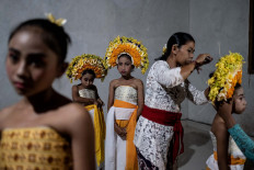 The girls chosen to perform the Sanghyang Dedari dancer put on headdresses as they prepare to perform. The crown is made of pomelo skin and five different flowers: frangipani, gumitir, cempaka, kenanga and Asian Pigeonwings. JP/Agung Parameswara