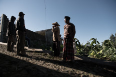 Tobacco farmers gather for a convivial morning discussion on the streets of Bowongso. JP/Dottie Bond