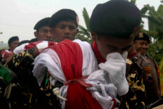A member of Banser is overcome with emotion while carrying the giant flag. JP/Maksum Nur Fauzan