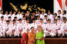 First Lady Iriana (center); Mufidah Kalla, wife of Vice President Jusuf Kalla; and Coordinating Human Development and Culture Minister Puan Maharani pose with members of the national flag-hoisting team during the inauguration of the team at the State Palace on Aug. 15. JP/ Seto Wardhana