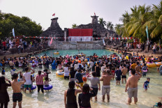 Visitors of Atlantis Water Adventures at Ancol Dreamland Park in North Jakarta observer a giant flag-hoisting ceremony in the pool area on Saturday.JP/Anggie Angela
