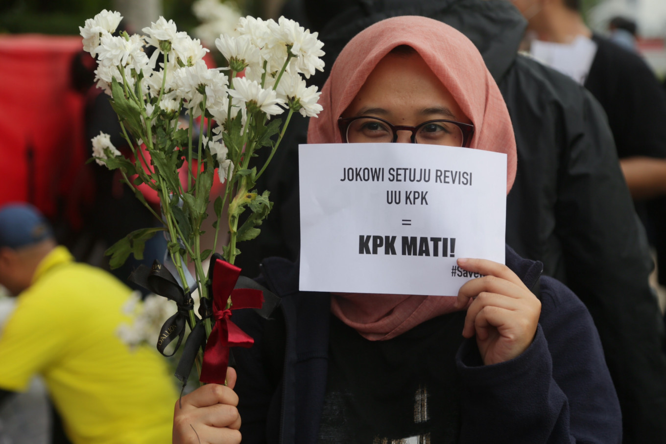 Resistance: A Corruption Eradication Commission (KPK) staff member carries flowers to be given to members of the public during a rally on the sidelines of a Car Free Day event at the Hotel Indonesia traffic circle in Central Jakarta. She also holds a piece of paper with a message that highlights KPK employees’ opposition to a revision of the 2002 KPK Law, which they say will weaken the antigraft body.