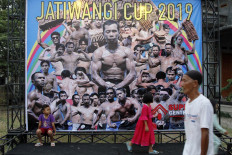 People pass the entrance door of the Dua Saudara jebor in Burujul Kulon, Majalengka, West Java, where the 2019 Jatiwangi Cup bodybuilder championship was being held as a way of improving solidarity among the workers of some 200 traditional roof tile factories in Jatiwangi district. JP/Arya Dipa
