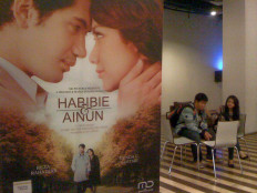Teenagers wait for a film screening near the poster of Habibie & Ainun at the CGV Cinema - Teraskota in South Tangerang, Banten, on January 19, 2012. JP/ R. Berto Wedhatama

