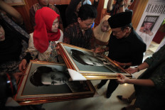 Indonesia's third president BJ Habibie signs a picture of a younger version of himself during the launch of the Habibie Series book at the Habibie and Ainun Library in Jakarta on June 23, 2016. The launch was in conjunction with BJ Habibie's 80th anniversary. JP/Dhoni Setiawan
