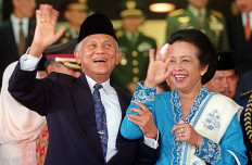 Indonesian President B.J. Habibie and his wife, Hasri Ainun wave to journalists outside the Parliament building in Jakarta 01 October 1999 shortly after attending a swearing in ceremony for new members of Parliament.  The 700 members of the People's Consultative Assembly (MPR) and 500 member's of the People's Representative Council (DPR) were sworn in amid tight security and heavy pressure from opposition parties to shrink six-week timetable and move swiftly to the selection of a successor to President B.J. Habibie. AFP/Str