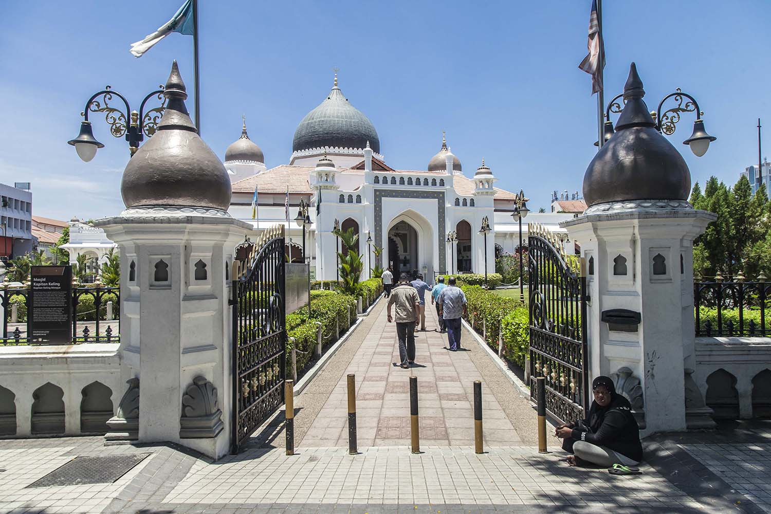 Worshipers enter the grounds of Kapitan Keling Mosque. Built in 1801, Kapitan Keling Mosque was the first Islamic institution to be built in George Town, Penang. This Moorish and Mugal architectural style place of worship is the largest mosque in Penang. JP/Irene Barlian