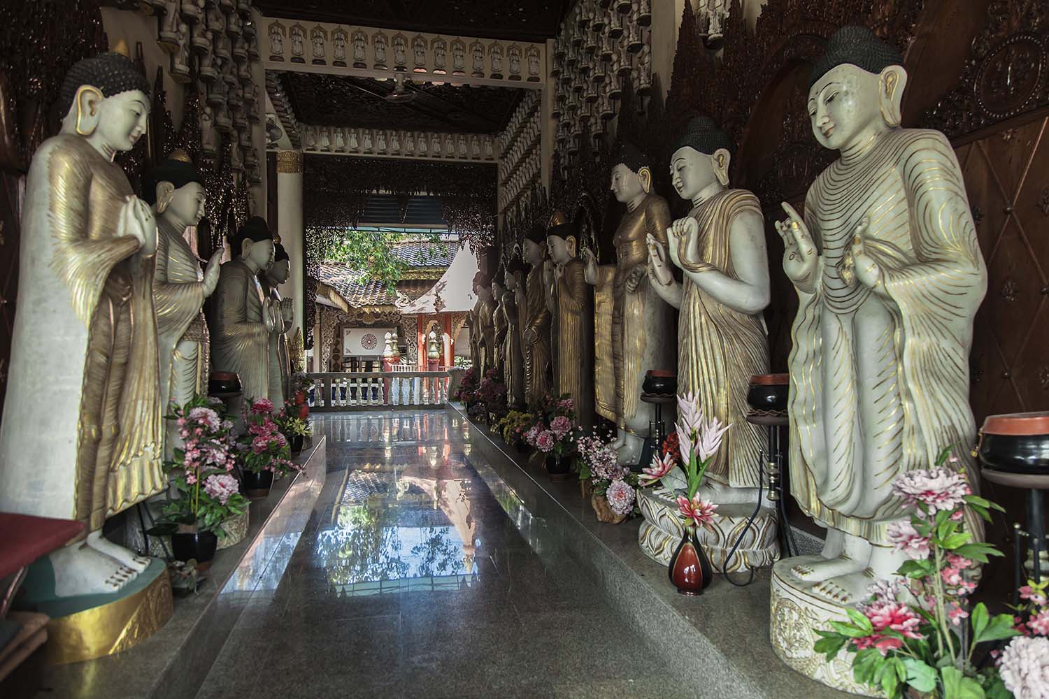 A row of standing Buddha statues at Dhammikarama Burmese Temple. Built in 1805, the temple was the first Burmese temple to be built in Malaysia. JP/Irene Barlian
