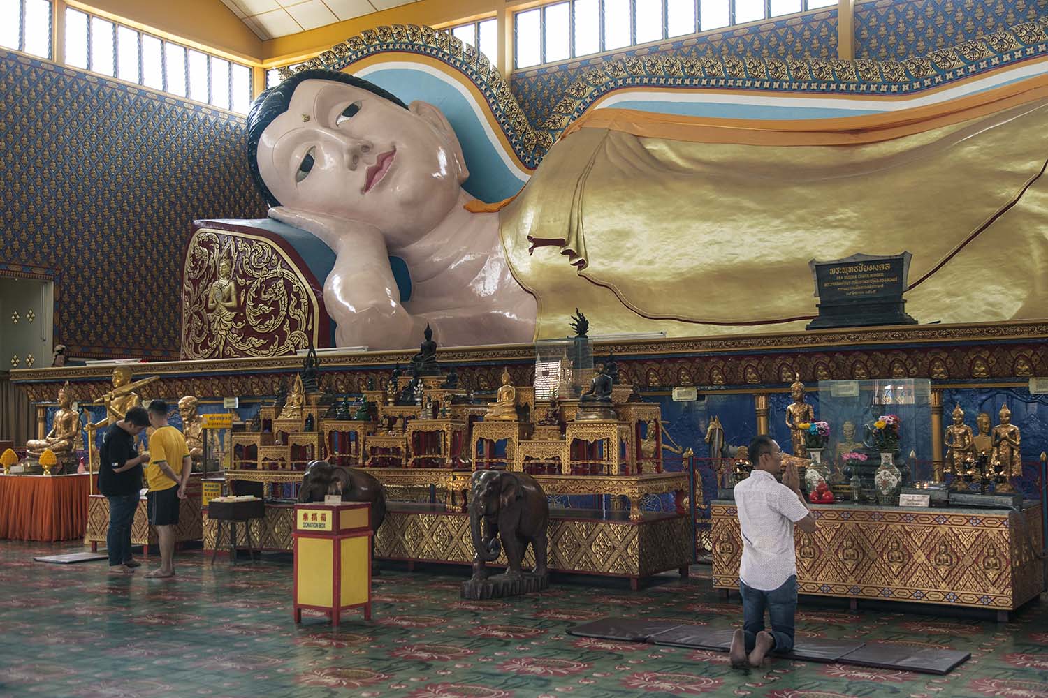 A 33-meter-long reclining Buddha statue is located in the main room of Wat Chayamangkalaram. It is one of the longest reclining Buddha statues in the world. JP/Irene Barlian